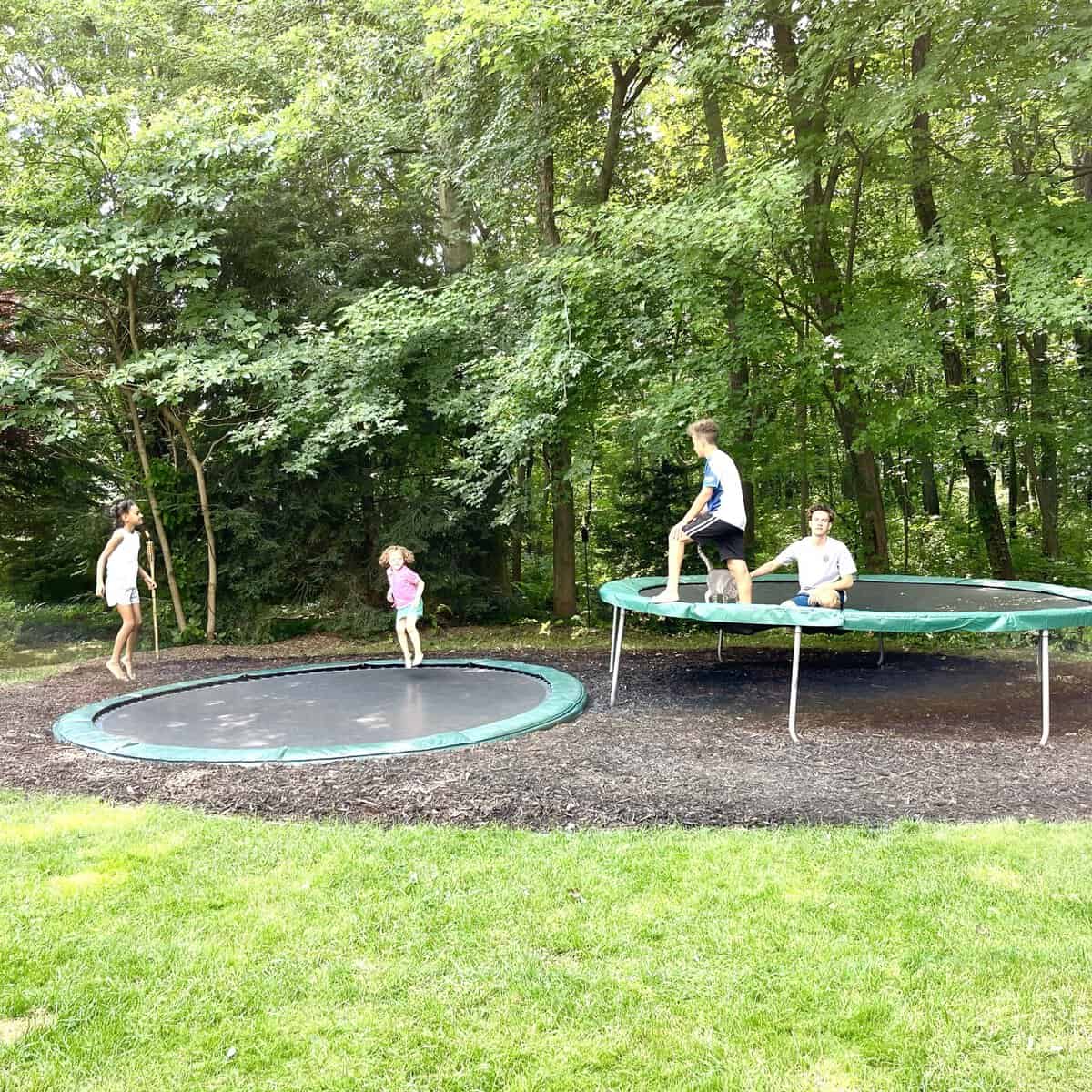 kids jumping on an inground and above ground trampolines 