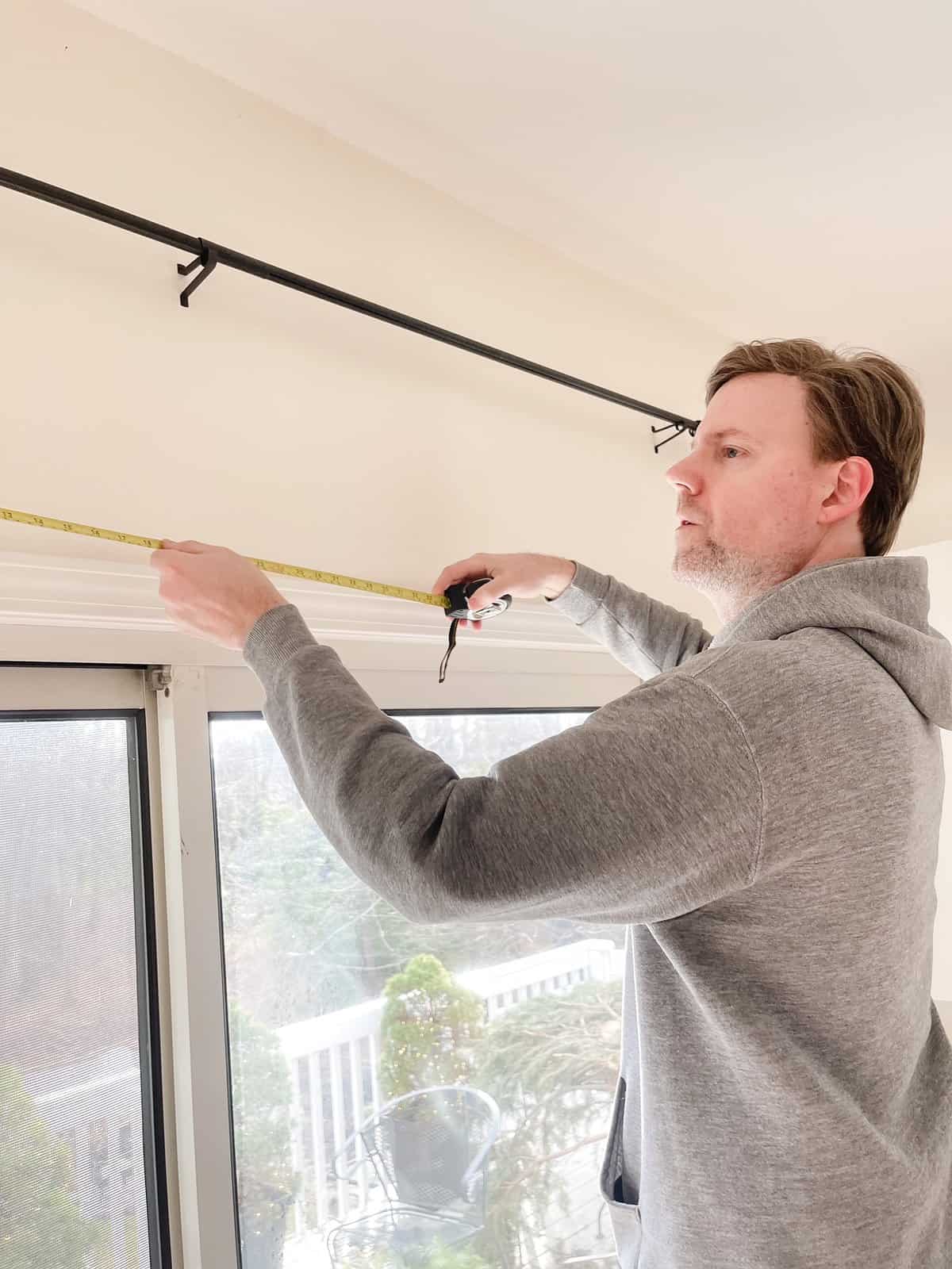 man installing curtain rod