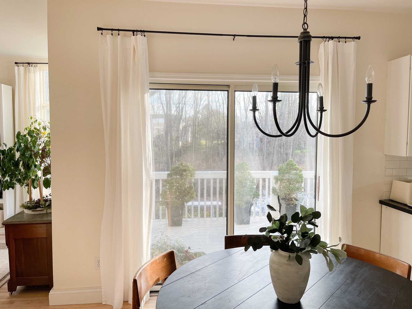 dining room with black round table white curtains