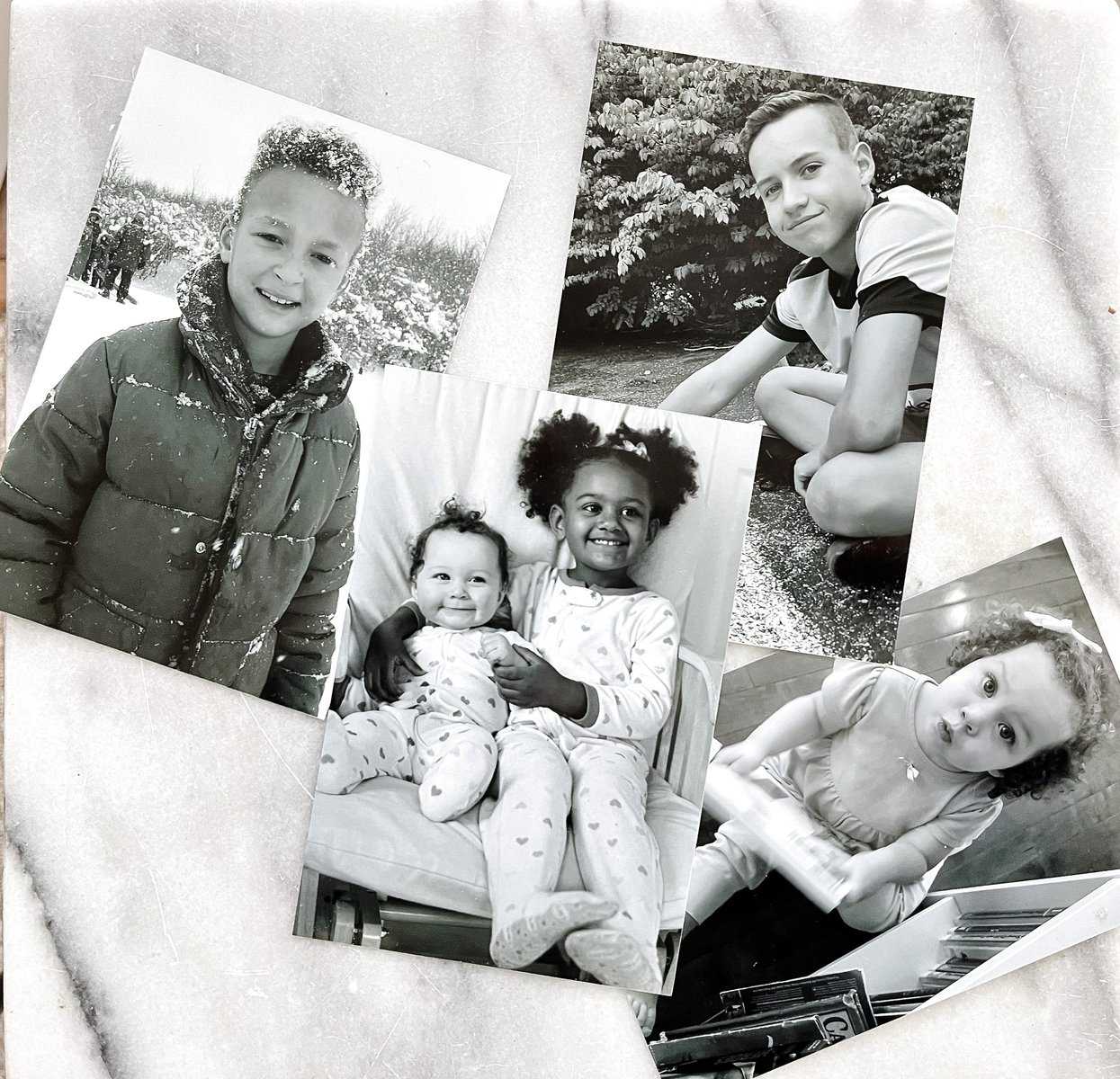 A flat lay of black and white family photos on marble.