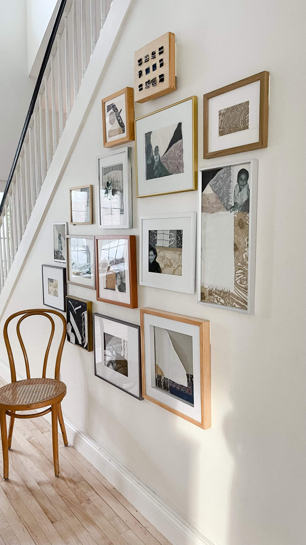 A family photo and art gallery wall in a hallway.
