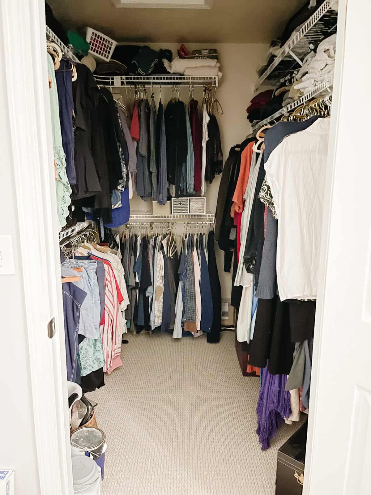 walk in closet stuffed with clothing in need of organization