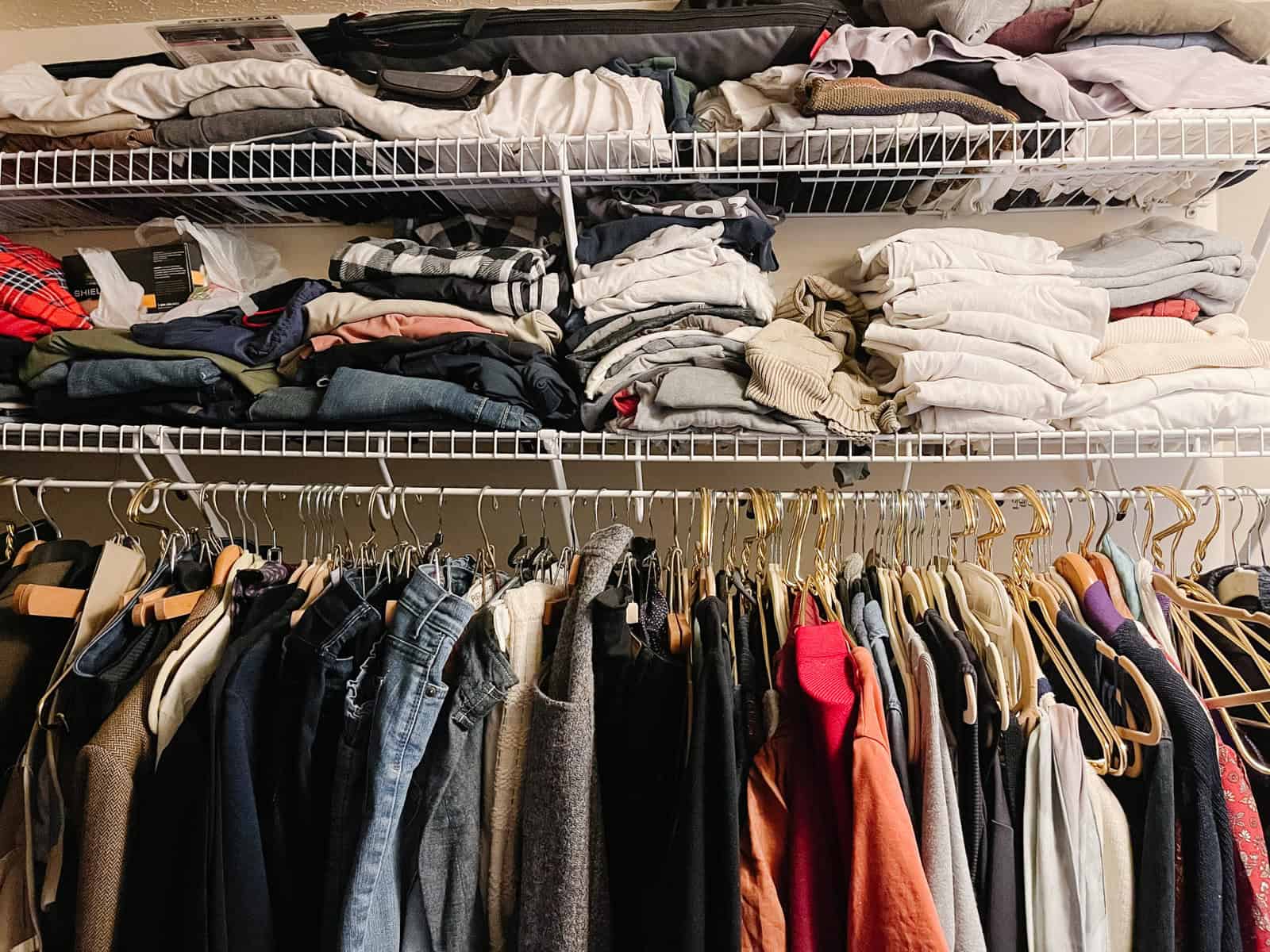 hanging and folded clothes in a closet