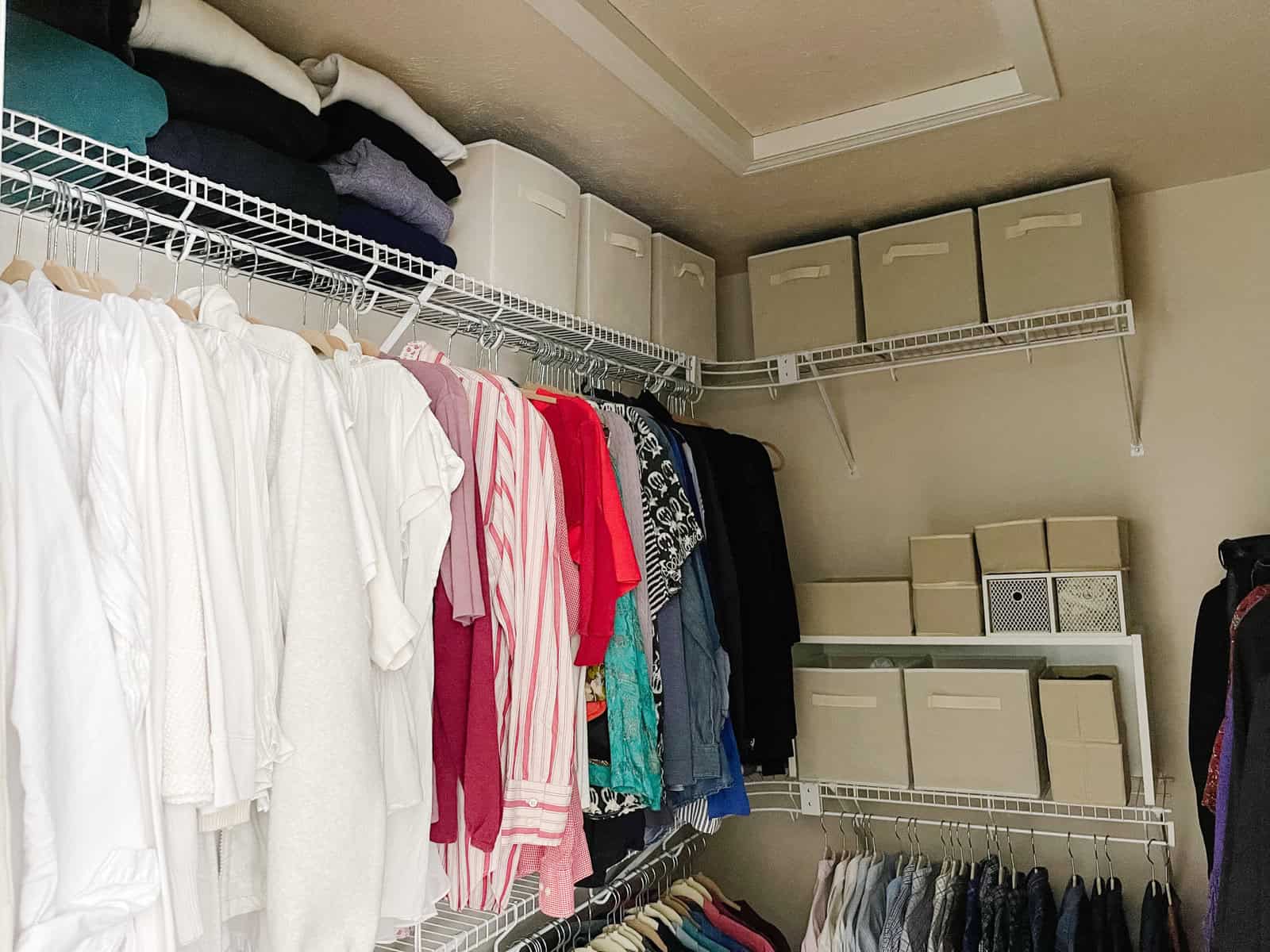 organized walk in closet with fabric box storage