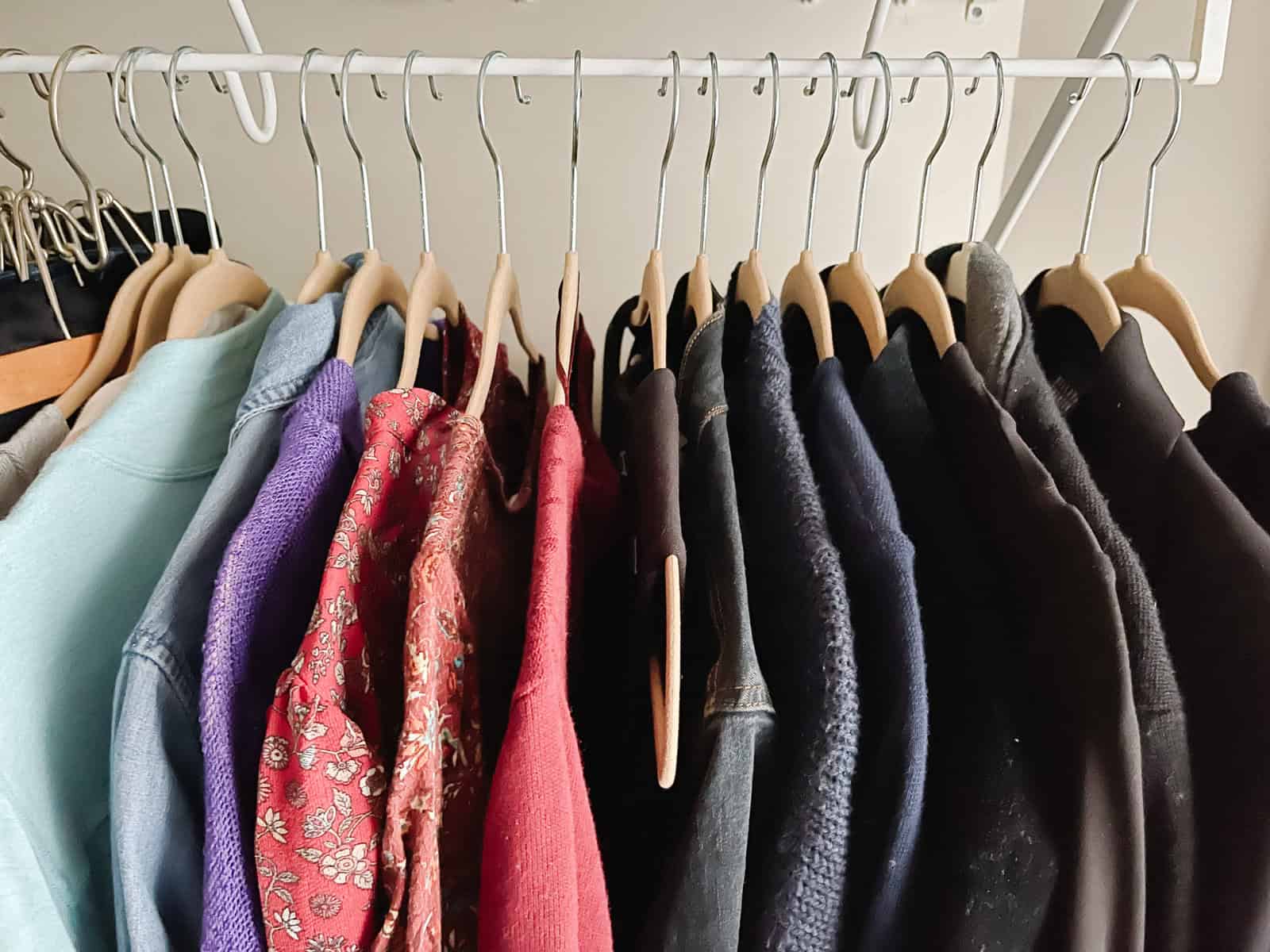 color coordinated clothing on velvet hangers neatly organized