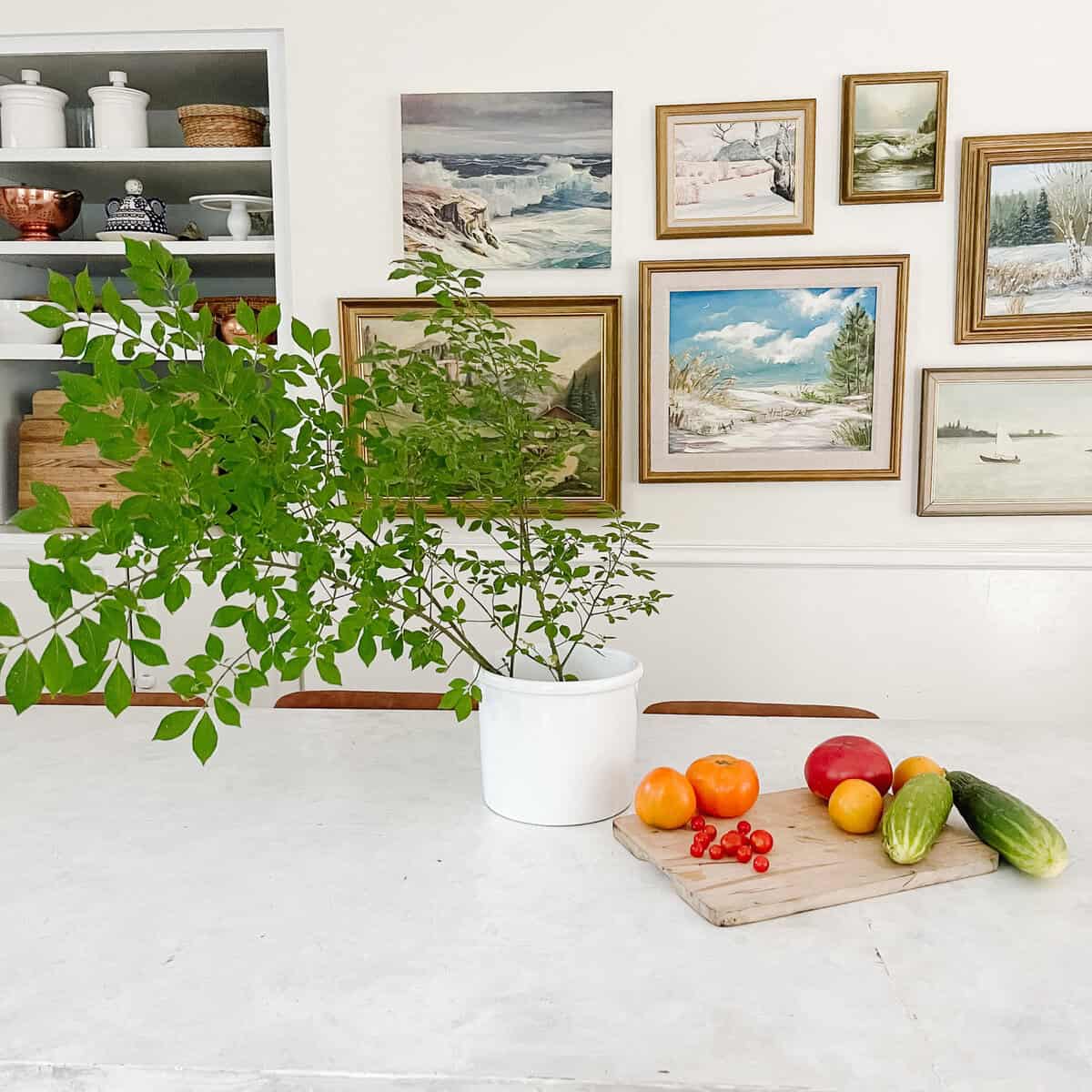greenery on kitchen island and vintage art gallery wall